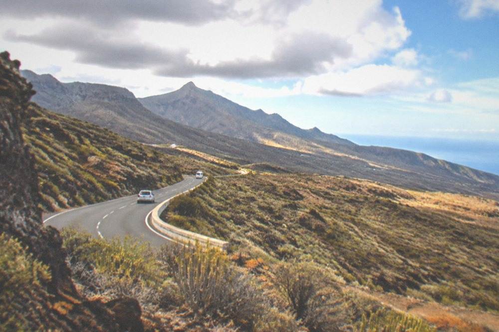 A road winding inland toward volcanic peaks seen from the east coast