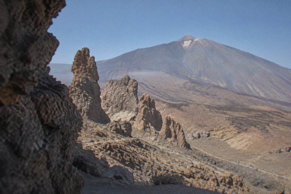 Rock formations of the Roques de Garcia standing on a ridge inside Teide National Park with Mount Teide behind them