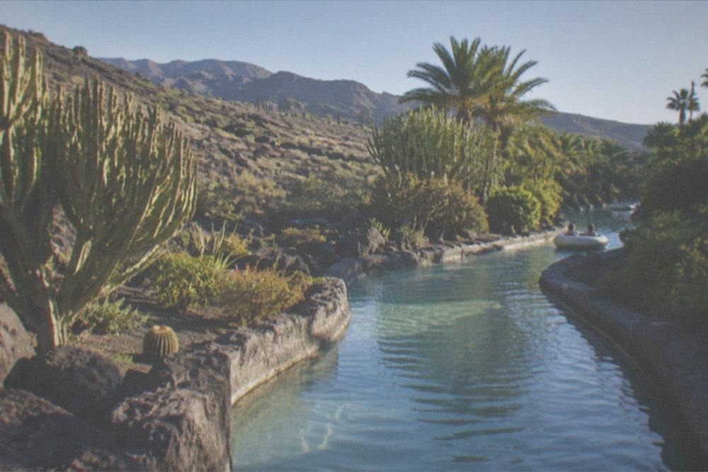 A slow water channel winding through tropical gardens inside a water park
