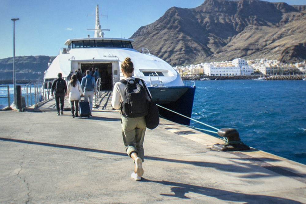 Passengers boarding a fast ferry at a Canary Islands port in morning light