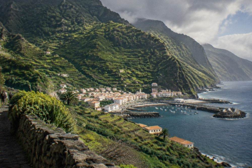 Green terraced hillsides of La Gomera rising above a small coastal town