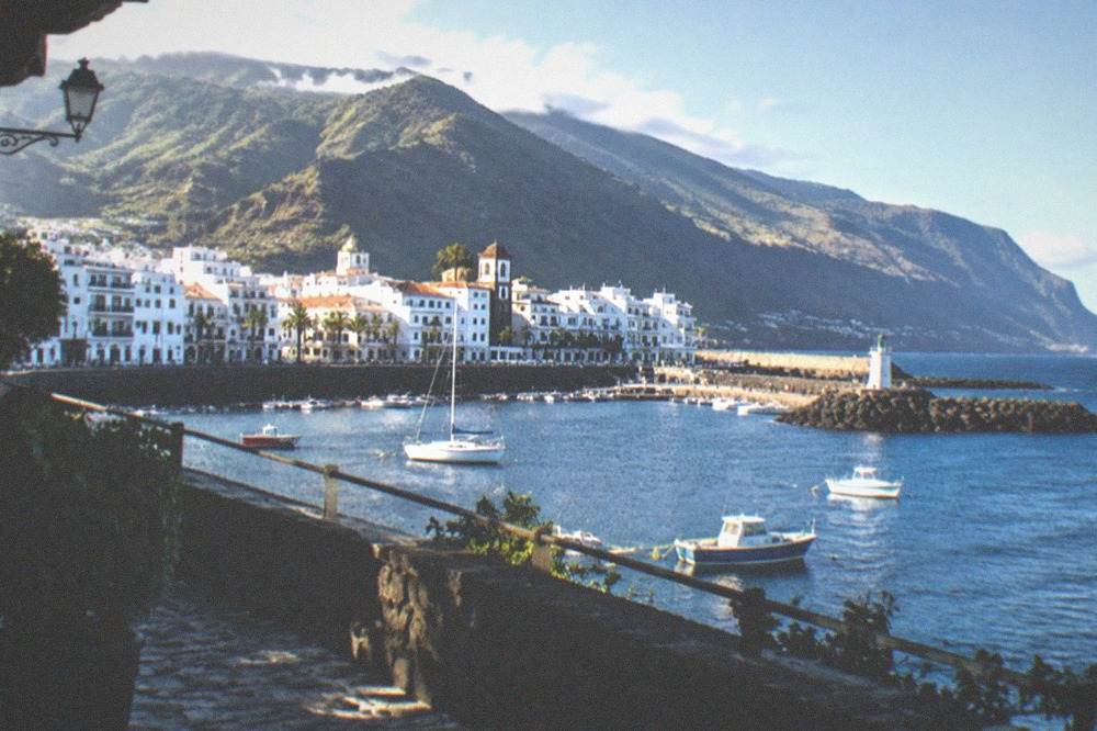 A coastal Canary town with white buildings along a harbour front