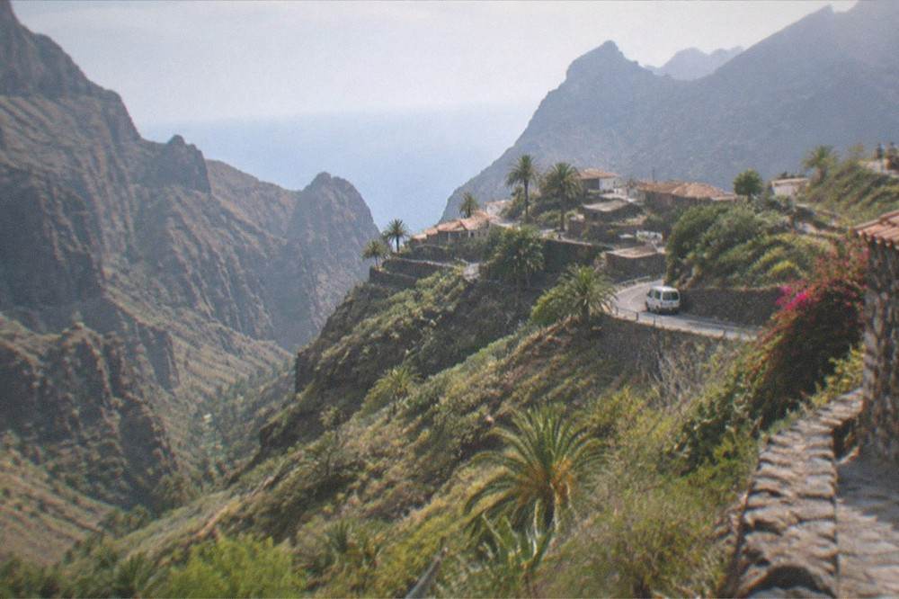 A terraced mountain village with stone houses on a ridge above a deep ravine