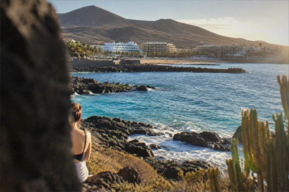 Turquoise water over volcanic rocks near Playa de las Vistas in Los Cristianos