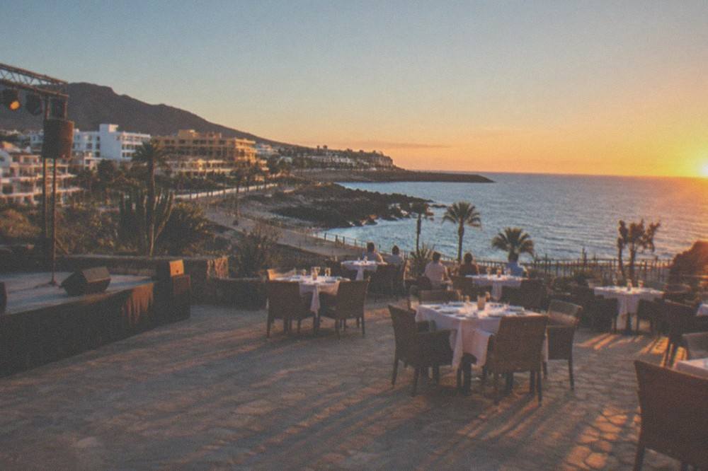 An illuminated courtyard at dusk with tables set for an evening show