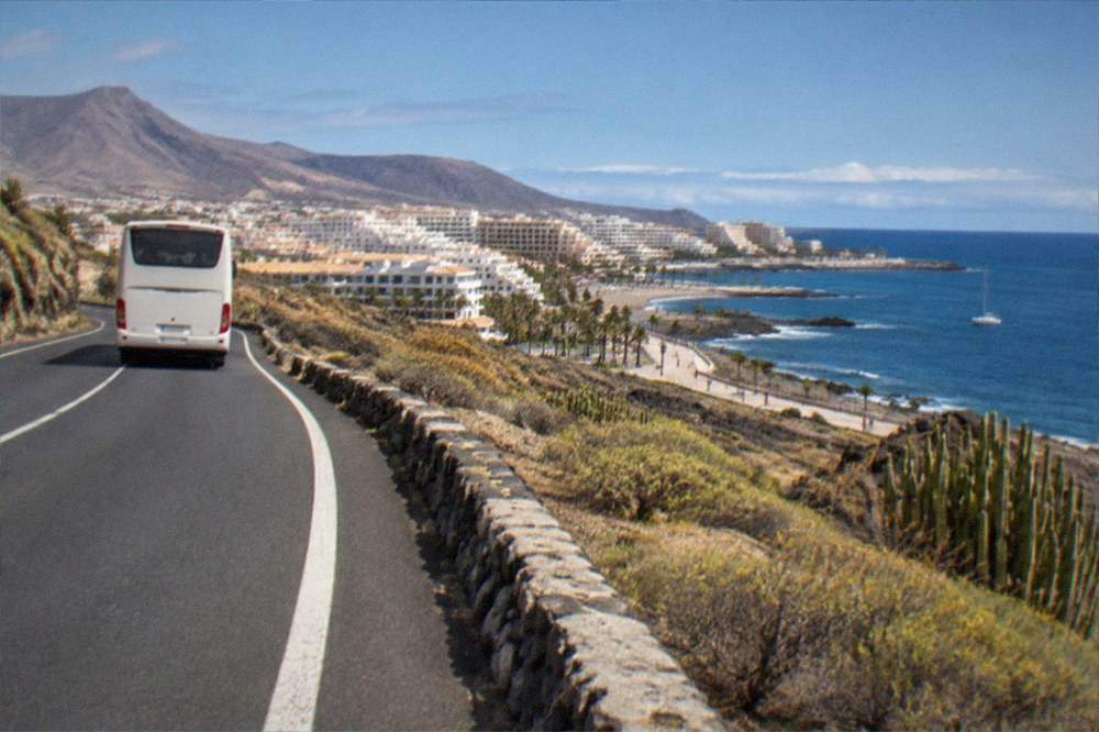 A road above the coast with an island bus heading towards resort hotels