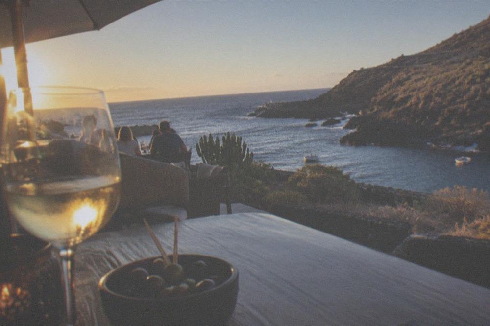 A restaurant terrace lit for the evening beside a harbour