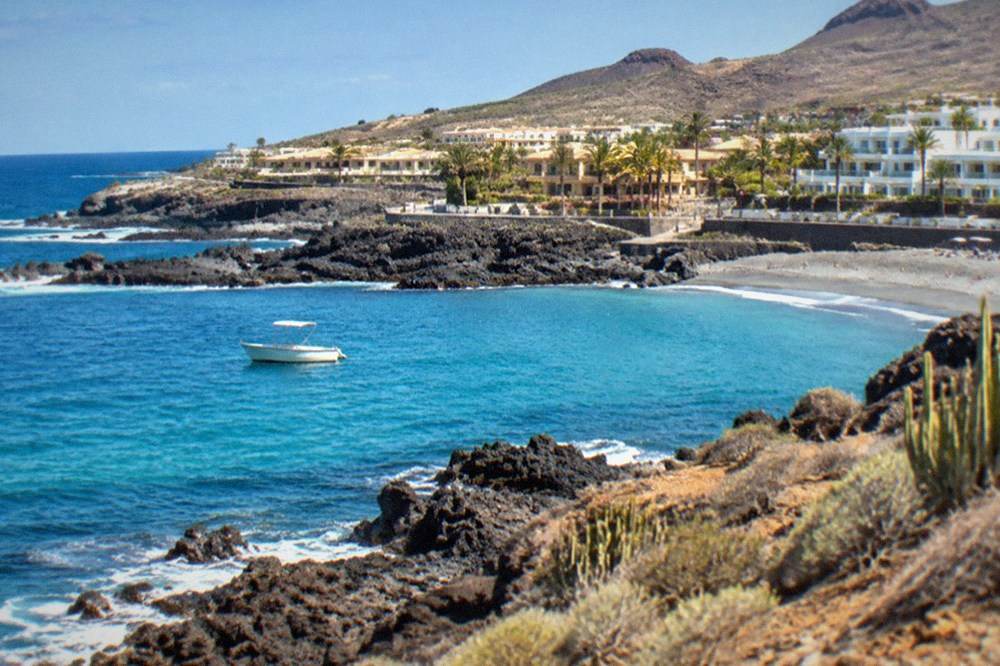 Clear turquoise water along a rocky coastline with a small boat