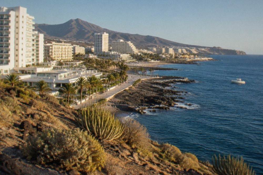 White high-rise hotels along the seafront at Costa Adeje under a clear sky