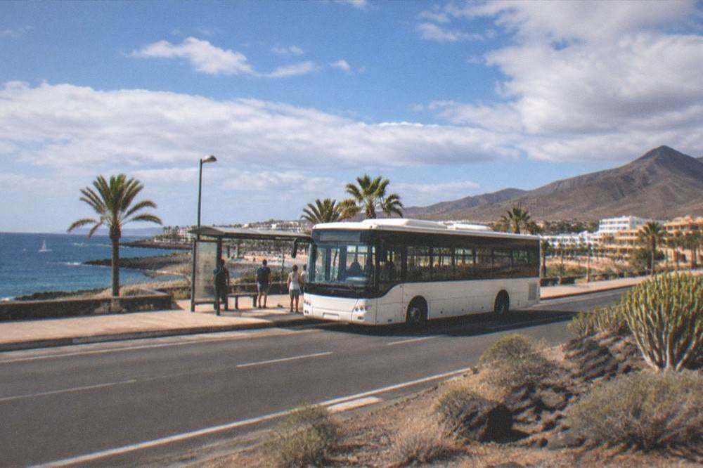 An island bus at a stop on a coastal road in Tenerife