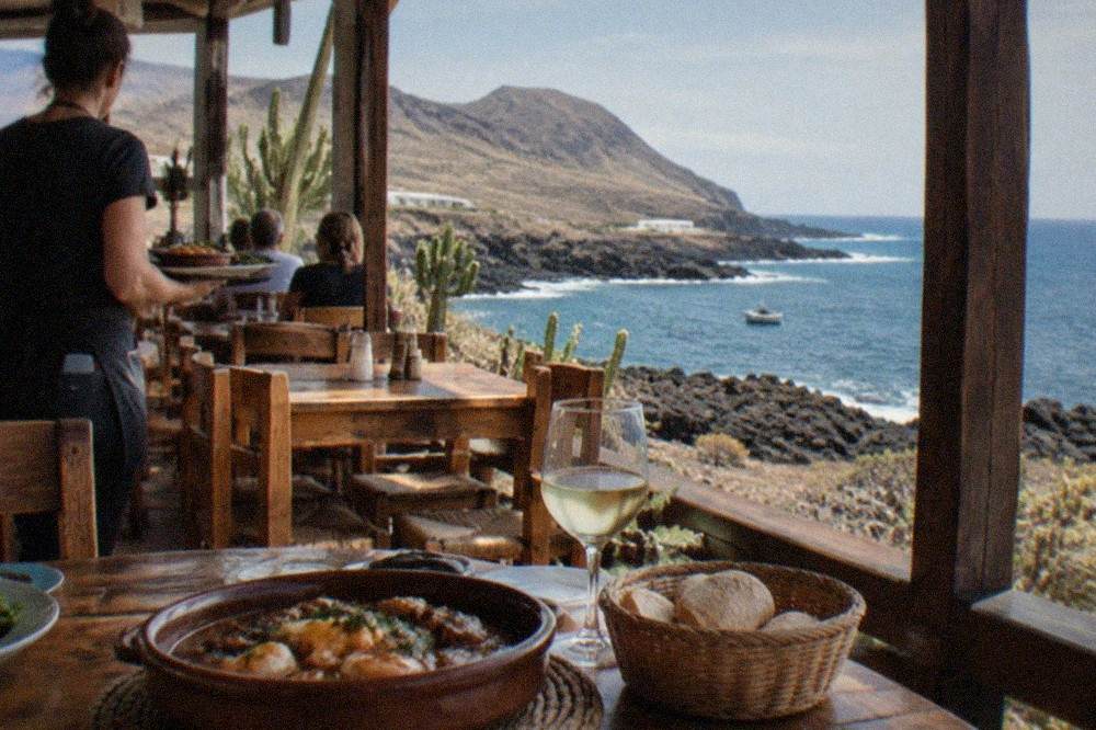 A busy Canarian restaurant interior with wooden tables and local dishes being served