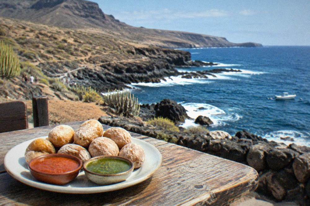 A plate of papas arrugadas with red and green mojo sauces on a rustic table