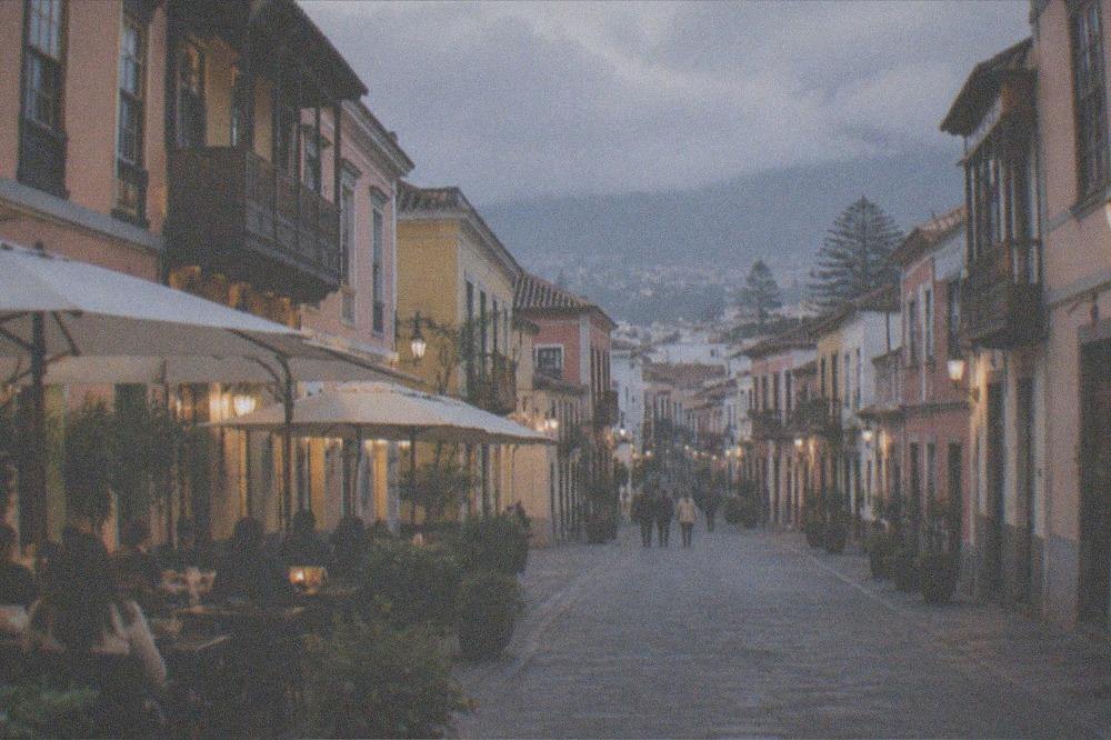 A colonial street in La Laguna with restaurant tables outside in the evening