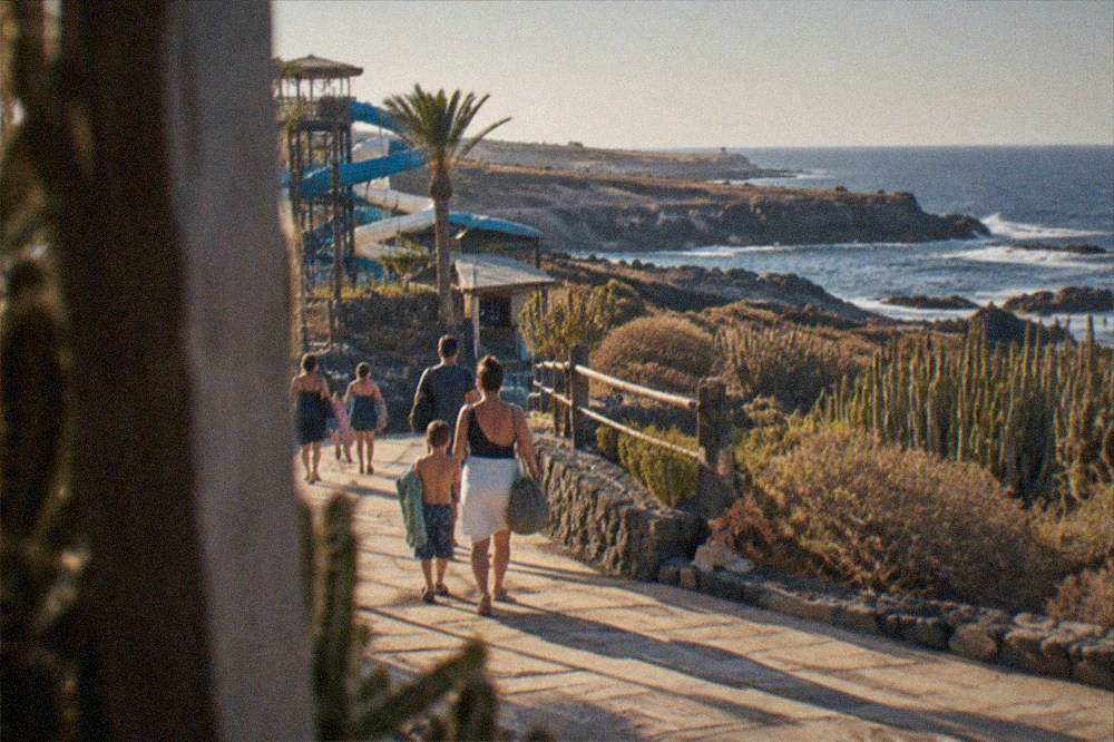 Families walking away from a water park entrance in the late afternoon