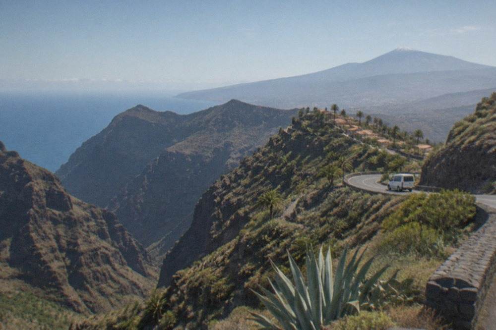 A road winding through volcanic landscape toward Mount Teide on a clear day
