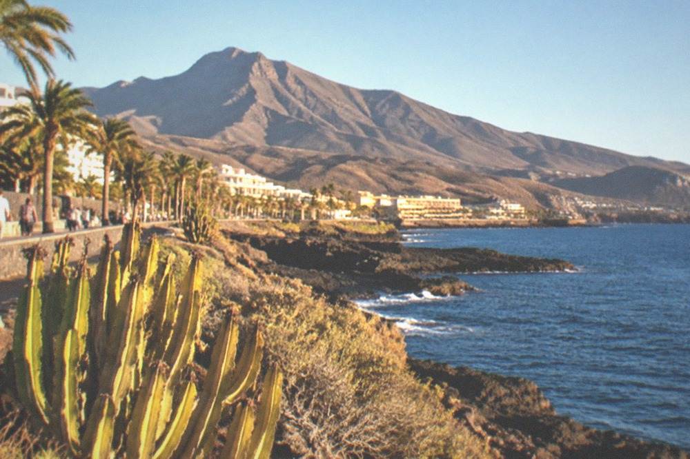 A volcanic mountain landscape with rocky slopes under a clear sky and no buildings in view