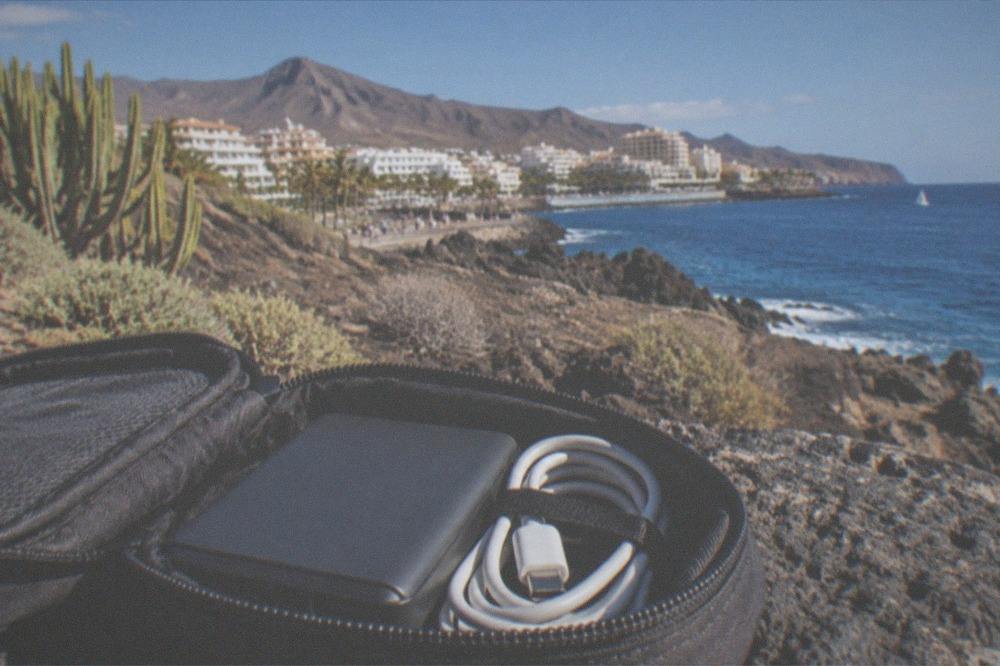 A power bank and coiled charging cable packed in a small travel pouch