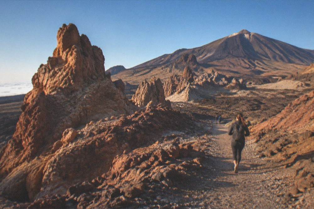 A volcanic landscape of red rock formations in Teide National Park under a clear sky