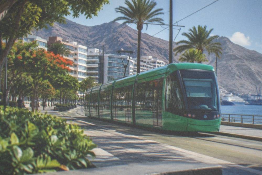 A green tram passing modern buildings in Santa Cruz de Tenerife