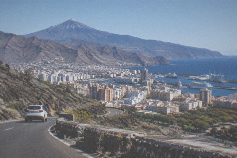 A road climbing through lava fields toward Mount Teide under a clear sky