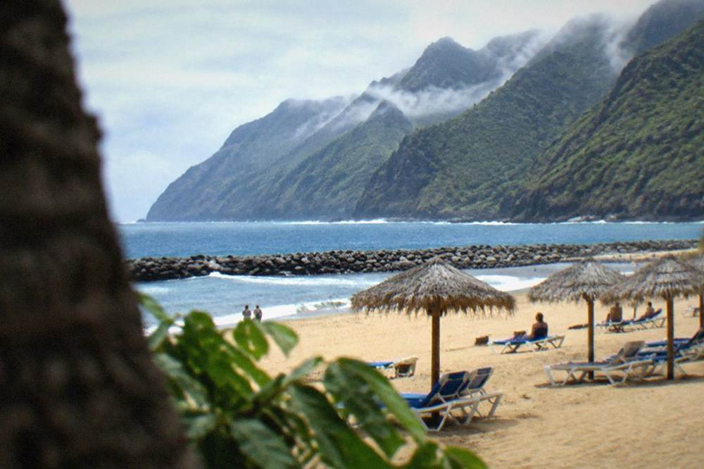 Sun loungers and parasols on a pale sand beach in a Tenerife resort