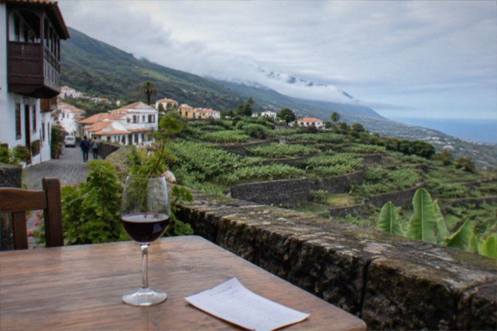 A handwritten bill resting on a tavern table beside a glass of red wine