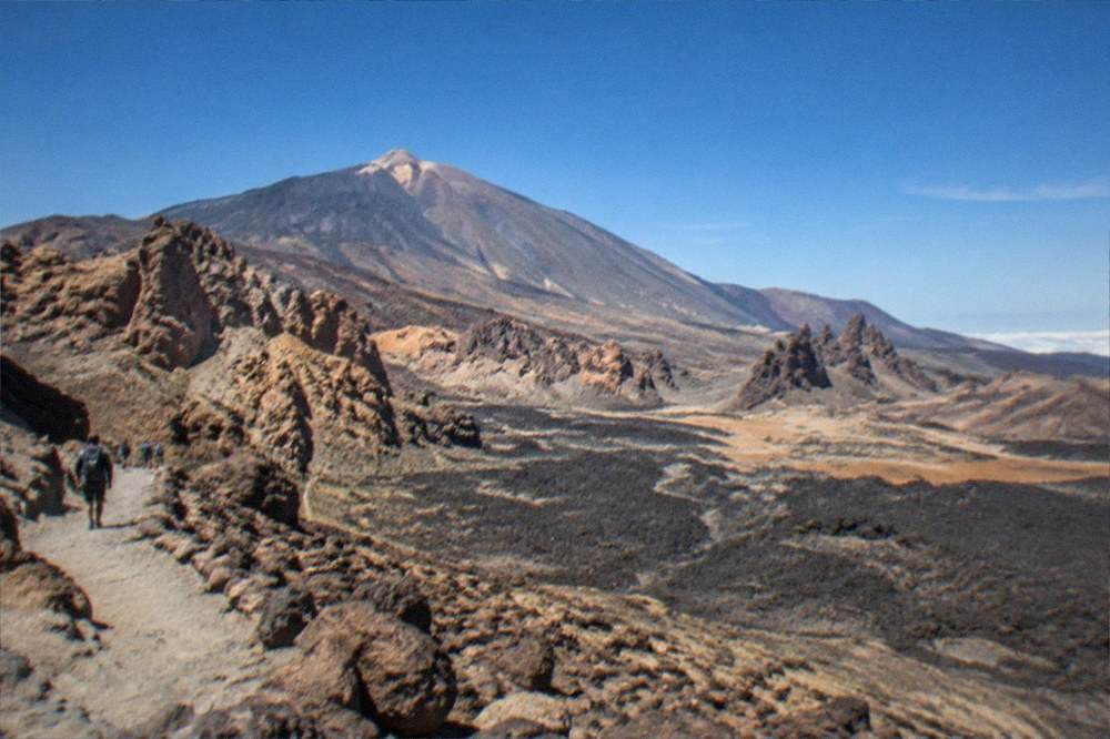 Dark volcanic rock and old lava flows filling the valley below Teide
