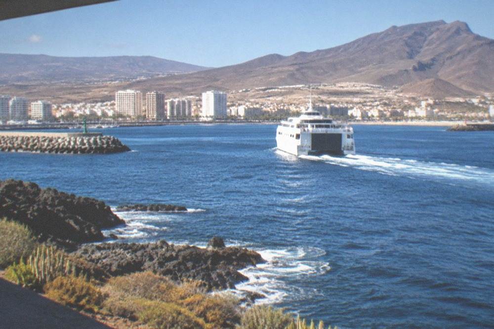 A ferry leaving a city port with a modern city skyline behind it