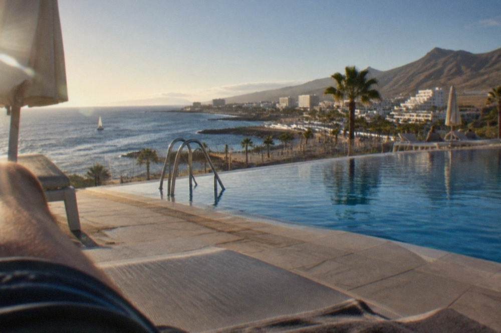 A hotel pool terrace overlooking the sea in a sunny southern resort town