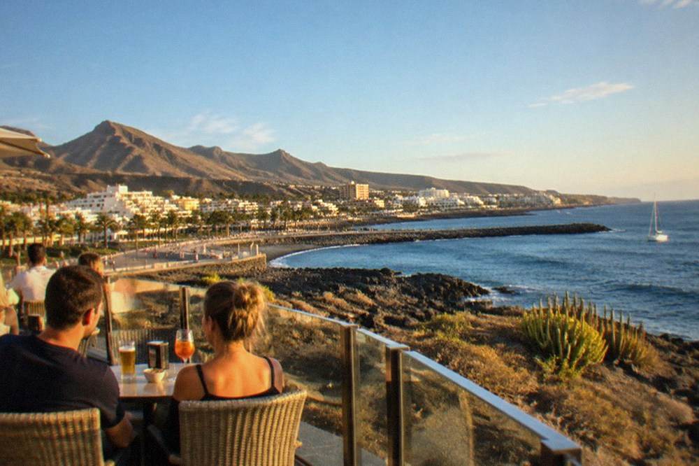 People enjoying drinks at an outdoor terrace bar in the evening