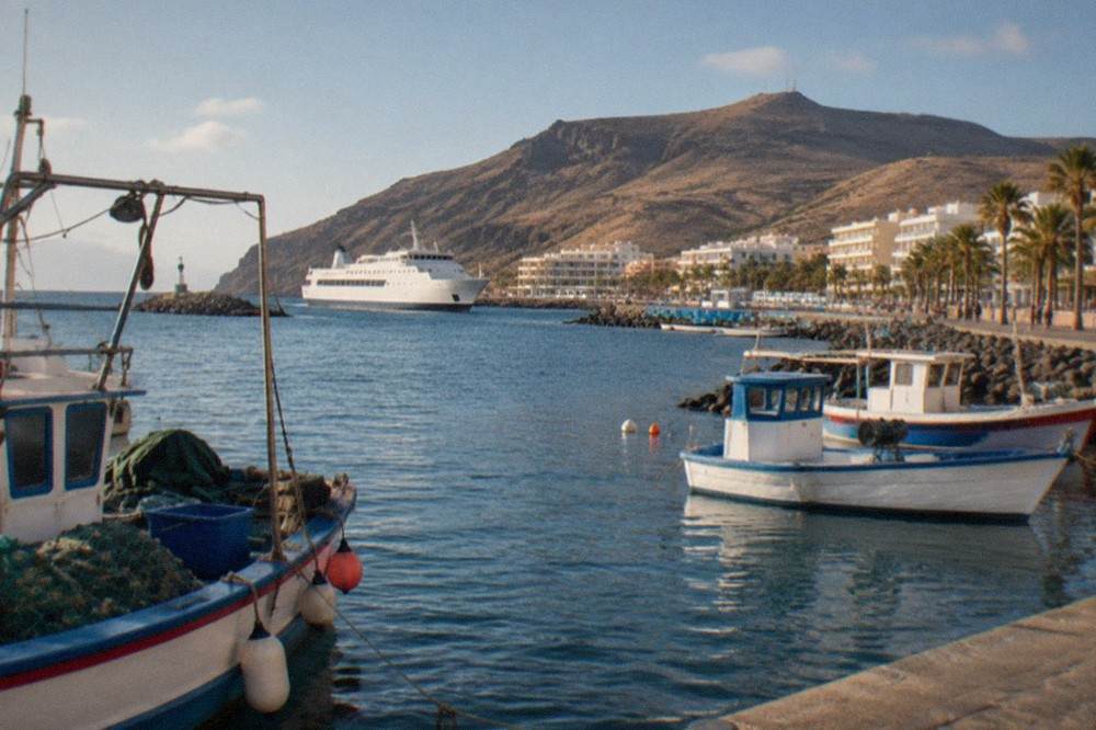 Fishing boats and a ferry in a small harbour town on Tenerife's south coast