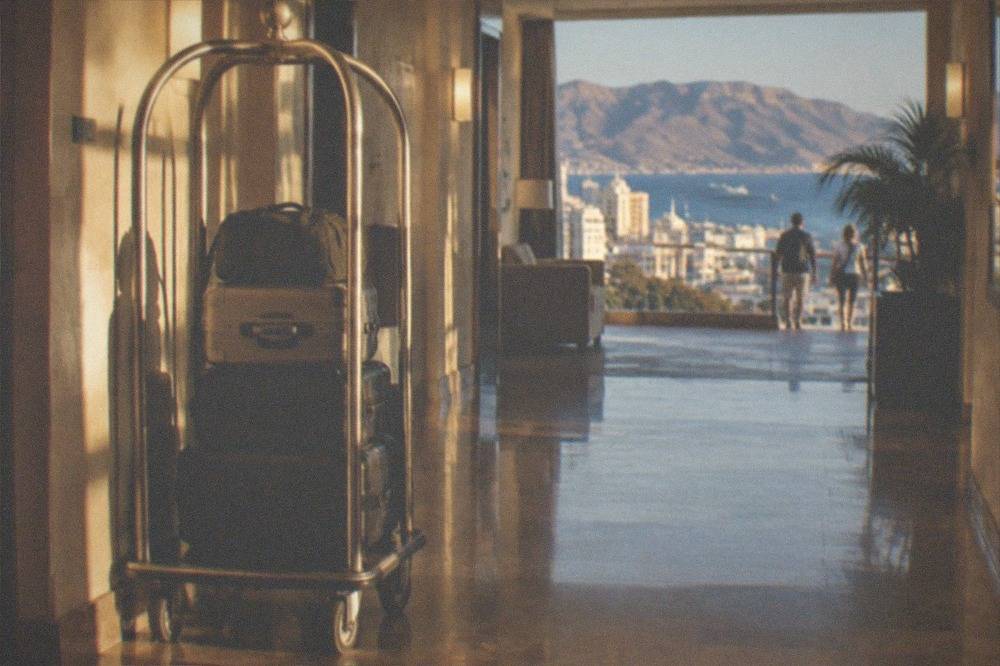A luggage trolley with stacked suitcases in a hotel corridor