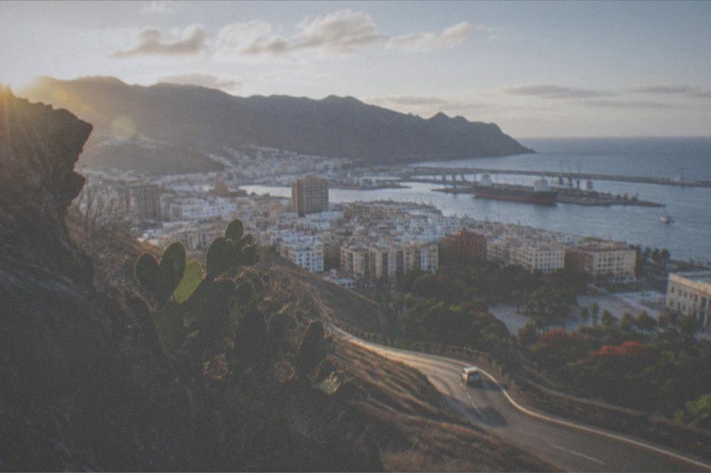 A volcanic rock landscape under a wide sky with a winding road below