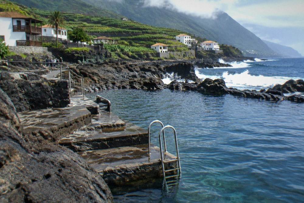 Steps and a metal ladder leading into a natural rock pool