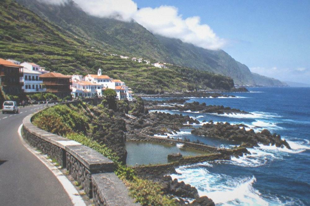 A coastal road winding above rock pools and the sea in northern Tenerife
