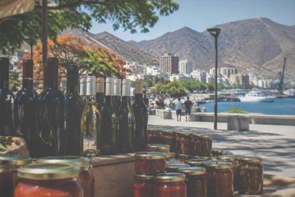 Bottles of local wine and jars of sauce arranged on a market stall