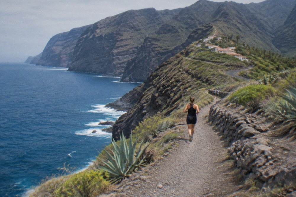 A coastal path near Los Gigantes with the ocean on one side and volcanic hills in the distance