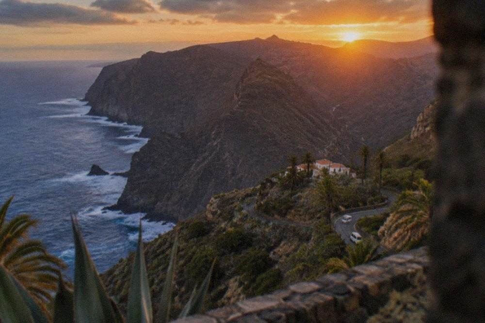 The sun setting over a volcanic ridge in Tenerife with orange light across the landscape