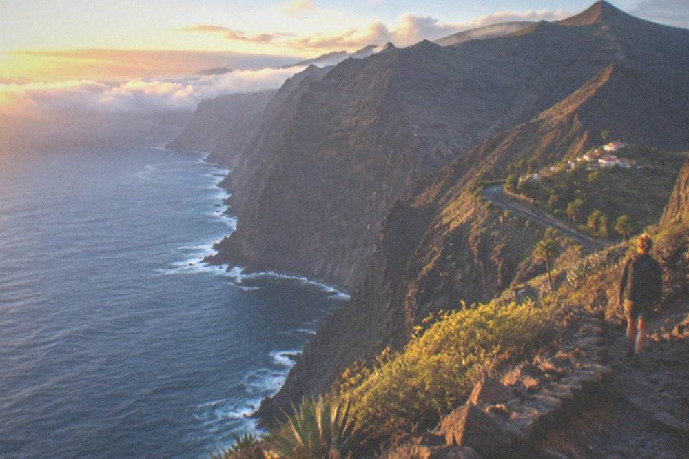 A high mountain trail above clouds in the late evening light