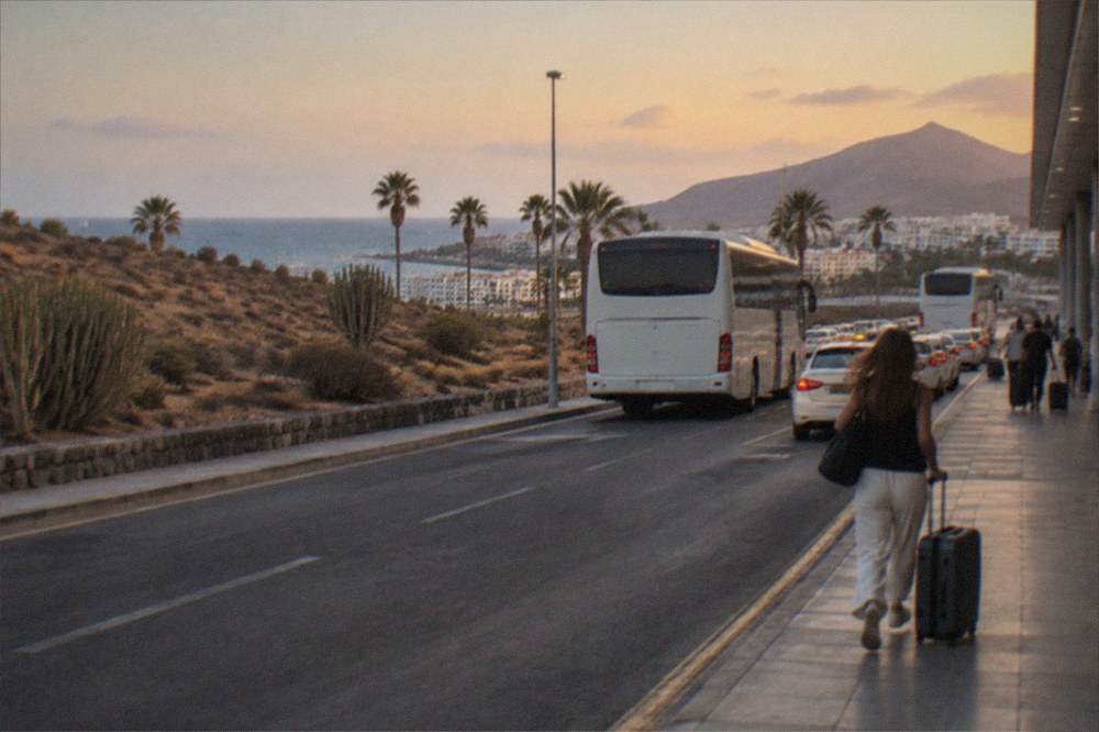 Buses and taxis at an airport forecourt in Tenerife under an evening sky