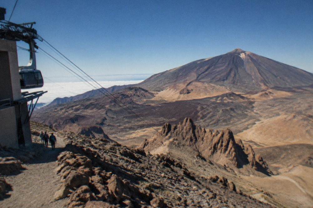 The upper cable car station at La Rambleta with the rocky slope of the summit trail behind it