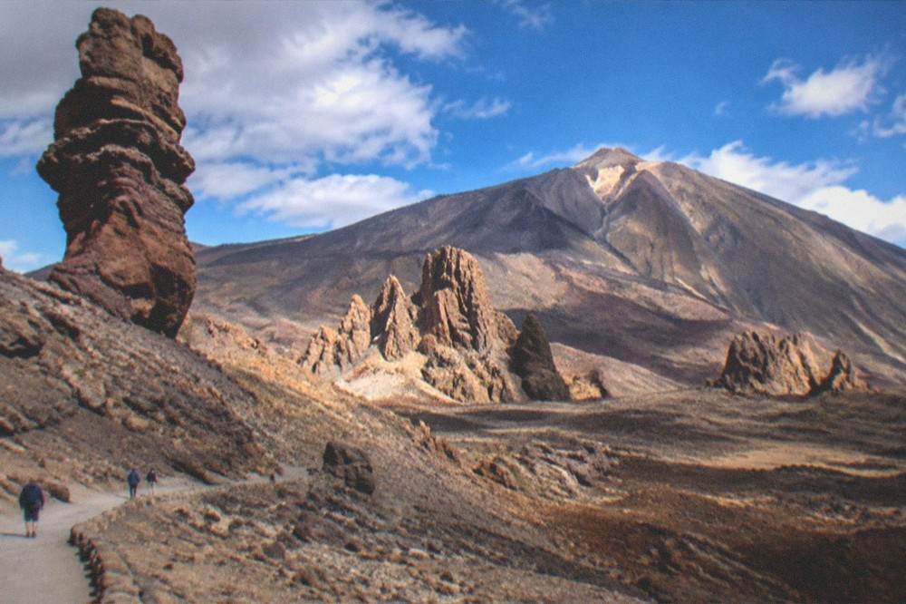 The Roques de Garcia rock formations standing on a flat volcanic plain below the mountain