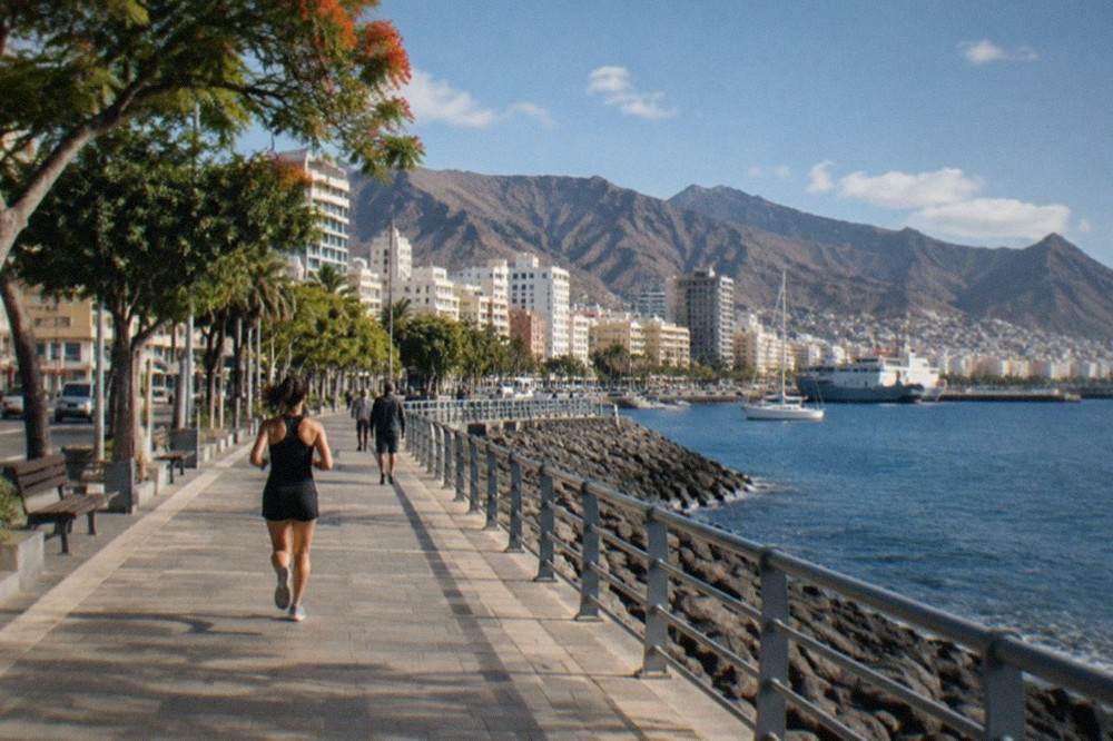 A coastal town in South Tenerife under sunshine with a calm blue sea in December