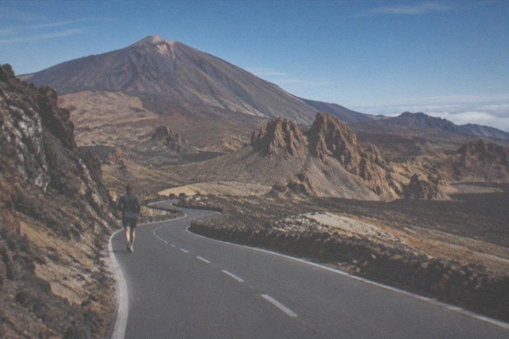 A winding mountain road in Teide National Park with volcanic rock on both sides