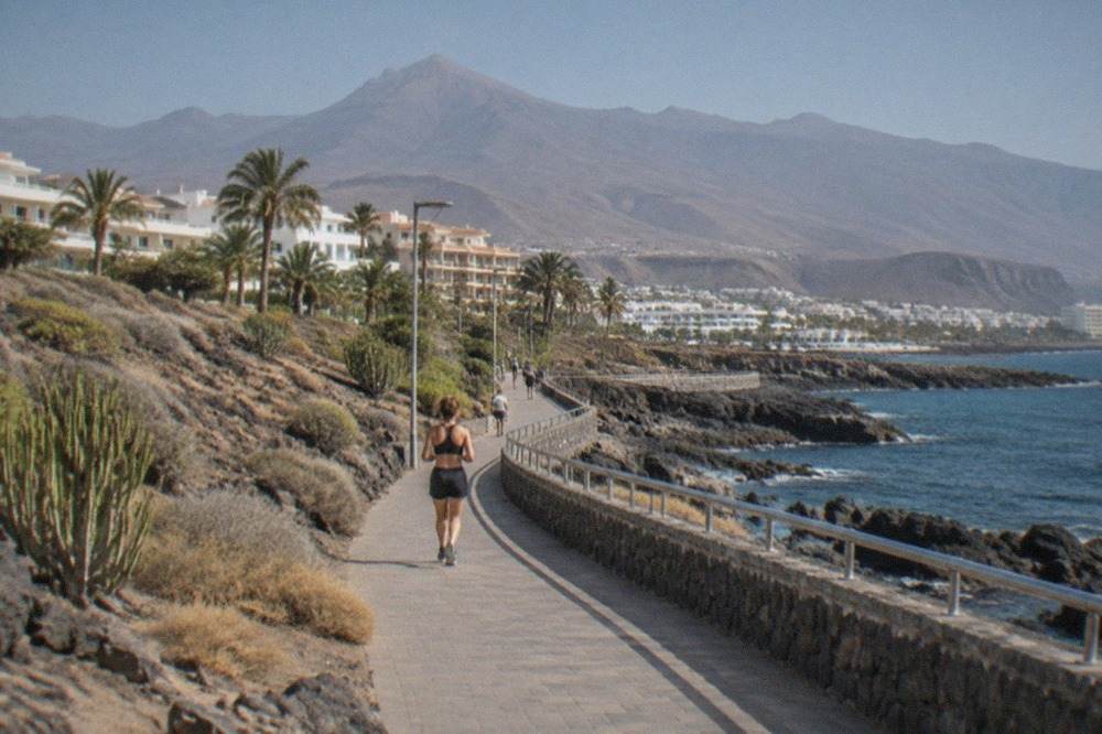 A view across a Tenerife resort coastline towards mountains under a clear sky