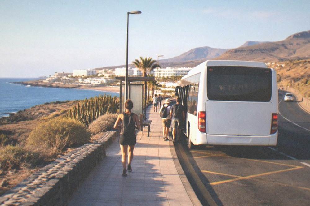 An island bus at a stop on a coastal road in Tenerife