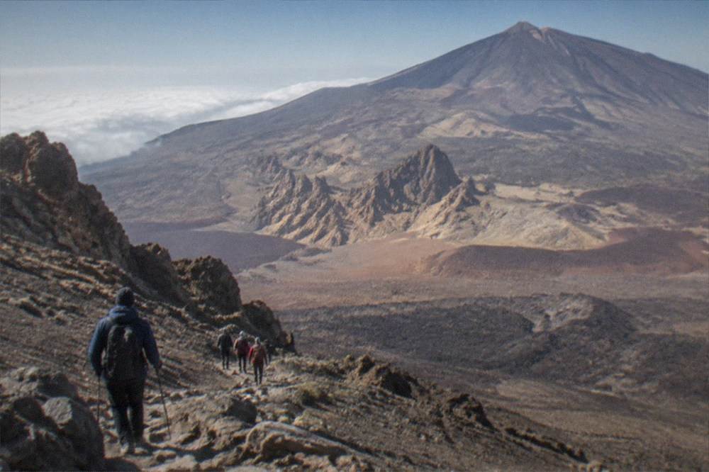 Hikers in warm clothing on a volcanic slope high on Mount Teide