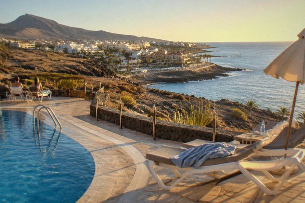 Swimming pool terraces and sunbeds on a warm afternoon in Costa Adeje