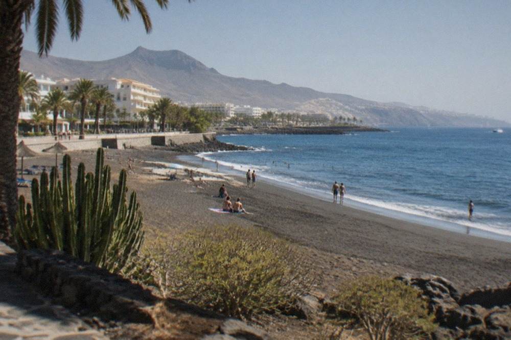 A sheltered sandy beach in south Tenerife under a clear winter sky