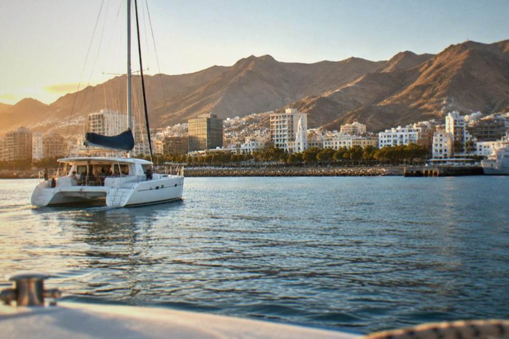 A catamaran on calm blue water near the Tenerife coast